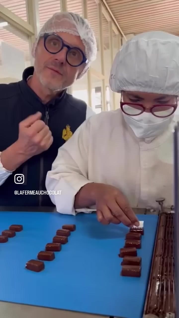 Grégoire Engrand forme une chocolatière, lui transmettant les gestes de l'alignement des ganaches avant enrobage