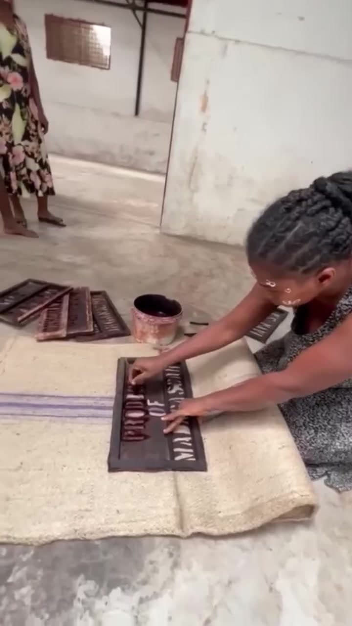 Pochoir en lettres rouges Produce of Madagascar peint à la main sur un sac de jute à la plantation MAVA